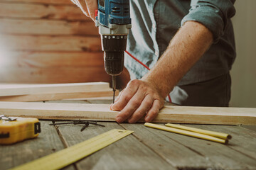 Close up of worker using electric scredriver on the table