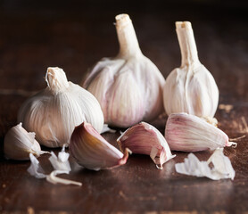 Garlic bulbs and garlic cloves on a dark rustig wooden table 