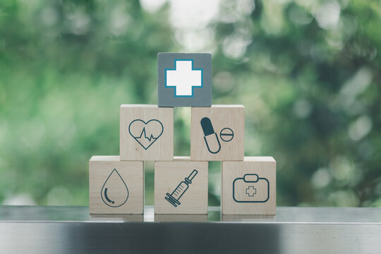Icon healthcare medical on wooden blocks stacked in a pyramid shape on a nature background. Medical and pharmaceutical concept