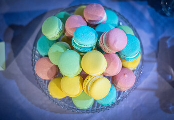 Fototapeta na wymiar Colourful macarons on a glass platter. Party, sweet, celebration, candies 