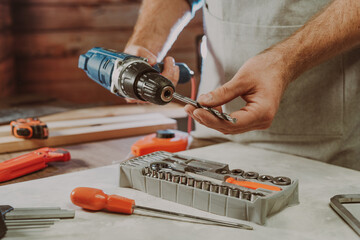 Close up of worker changing a drill for screwdriver