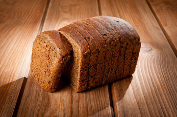 Bread made from natural products, on live sourdough, without baker's yeast, cut into skibbles on a wooden table surface.