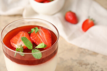 Glass with tasty strawberry panna cotta and mint on table, closeup