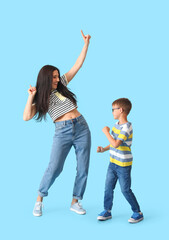 Dancing young woman and her little son on color background