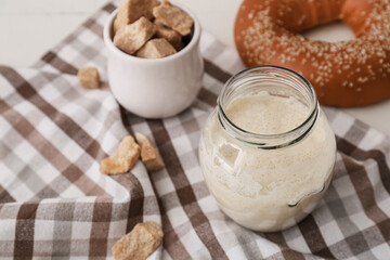 Glass jar with fresh sourdough on table