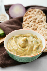 Bowl with tasty baba ghanoush on light background, closeup
