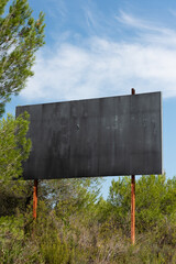 Empty advertising poster among bushes