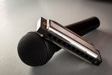 blues harp or harmonica with microphone on grey table ,hobby or pastime .