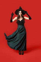 Beautiful woman dressed as witch for Halloween party on color background