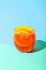 Glass of Aperol spritz cocktail on color background