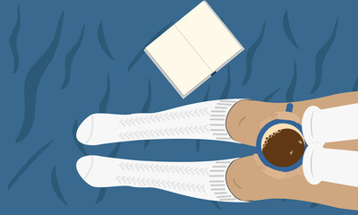 A girl in white socks sits on the bed and drinks coffee and reads a book. Girl on blue crumpled sheet