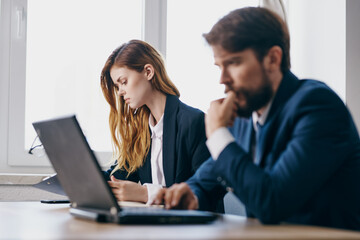 business man and woman sitting at a desk with a laptop communication finance officials