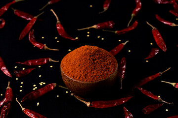 Pile crushed red pepper, Cayenne pepper, dried chili flakes isolated on black background