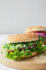 Wooden board with tasty vegetarian burger on table, closeup