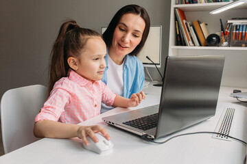 mom helps daughter do homework remotely on laptop