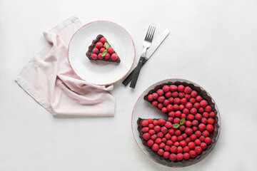 Plate with piece of tasty raspberry pie and mint on light background