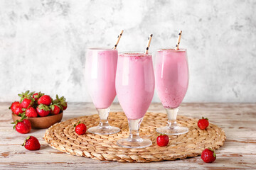 Glasses of strawberry Pina Colada cocktail and berries on light wooden table