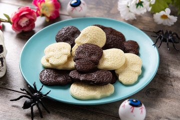 Chocolate Mexican skulls in plate on wooden table