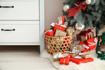 Advent calendar with gift boxes in basket under Christmas tree on floor