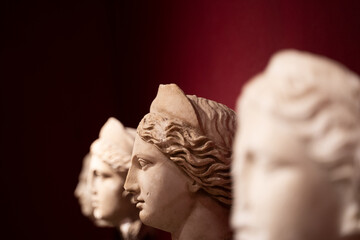 closeup of woman antique statues on red background
