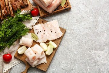 Wooden boards with salted lard on light background
