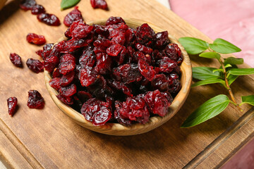 Bowl with tasty dried cranberries on table, closeup
