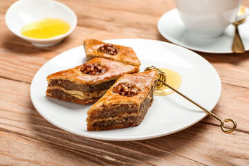 Plate with tasty baklava on wooden background