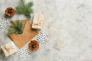 Fototapeta na wymiar Envelope with fir branches, gifts and snowflakes on grunge background
