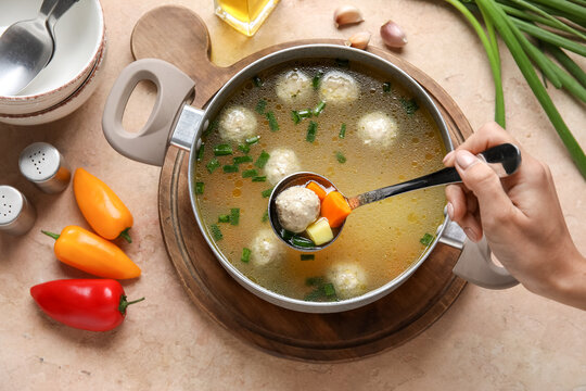 Woman Eating Tasty Meatball Soup On Color Background