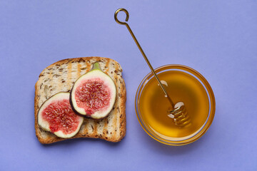 Toast with ripe figs and honey on color background
