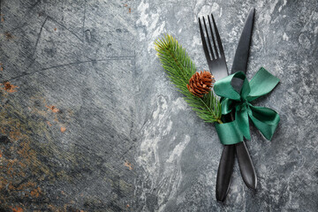 Black christmas cutlery with ribbon on stone