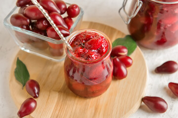 Jar of delicious dogwood jam on table, closeup