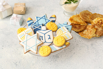 Dessert stand with tasty cookies for Hanukkah celebration on grey background
