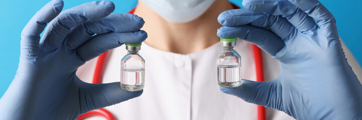 Doctor holds two medical ampoules with vaccine in his hands