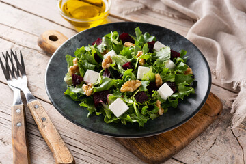 Beetroot salad with feta cheese,lettuce and walnuts on rustic wooden table