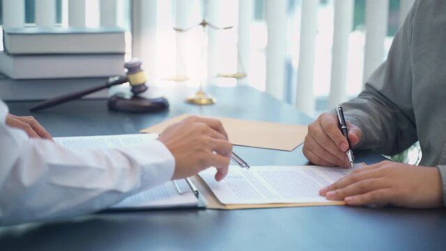 Lawyer preparing to sign a contract and wooden gavel on table justice and law concept
