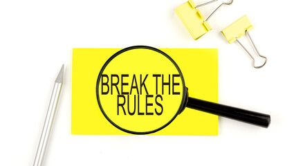BREAK THE RULES text on the sticker through magnifier. View from above. Business concept