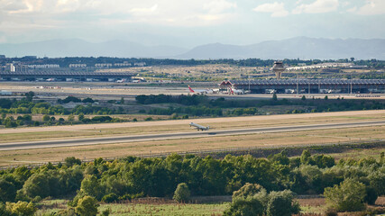 Fototapeta na wymiar Mitsubishi Crj -1000 aircraft of the Iberia Regional airline taking off from Madrid Barajas airport, also seeing the terminal and the control tower
