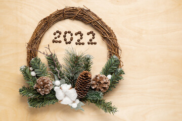 2022 number and eco Christmas wreath on wooden background .Top view
