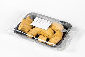 Freshly harvested ginger in a labeled pack on white background