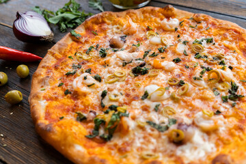 Pizza on the wood table. Concept promotional template for restaurant and pizzerias. Traditional Italian pizza with food ingredients and spices. Copy space. Top view. Banner. Pizza menu.