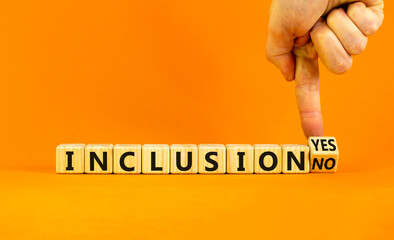 Inclusion yes or no symbol. Businessman turns a wooden cube and change words 'inclusion no' to 'inclusion yes'. Beautiful orange background. Business and inclusion yes or no concept, copy space.