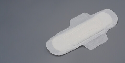Napkin sanitary. Soft and comfort sanitary napkin pad and grey background. White top sheet. Studio shot isolated. Cloth pads for menstruation. Wing type for night. Quick absorber. cotton soft feeling.