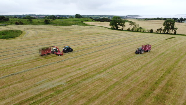 Drone shot of tractors making silage