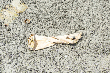 Rubber gloves Garbage that merchant ships dumped into sea during their voyage was washed by the wind and washed up on the sandy beach. Environmental pollution. Ecological problem.