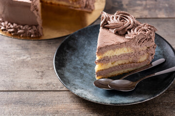 Piece of chocolate truffle cake on rustic wooden table