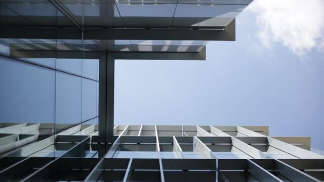 Metal and glass facade. Moderne architecture. Geometric facade. Aluminium frame.Reflections on glasses facade in a sunny day.