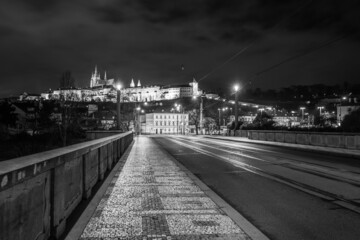 Illuminated Prague Castle by night. View from Manes Bridge. Prague, Czech Republic. Black and white image.