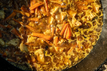 Cooking food on a fire, in a cauldron. Traditional Asian food is pilaf. Zirvak made from onions, oil, carrots, meat and spices. Mixed with rice. Prepared in a cauldron, over a fire. Birch firewood. Ru