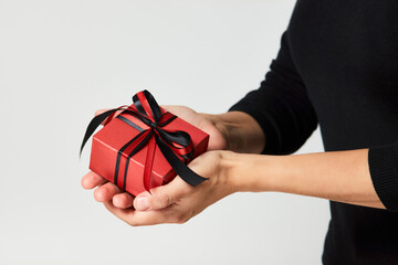 Woman hands holding small gift box with ribbon